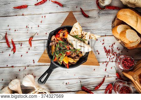 Top View On Mexican Dish Fajitos With Beef Vegetables And Pita In A Pan, Horizontal