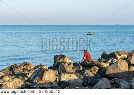 Poti, Georgia - 17, June 2020: Fisherman Fishes On The Black Sea, Poti