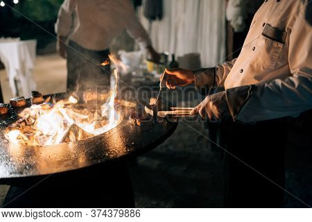 The Cook Measures The Temperature Of The Steak With A Thermometer On The Grill.