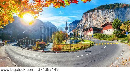 Gorgeous Autumn Landscape Of  Alpine Village Lauterbrunnen With Famous Church And Staubbach Waterfal