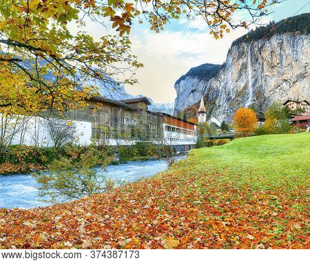 Amazing Autumn Landscape Of Touristic Alpine Village Lauterbrunnen With Famous Church And Staubbach 