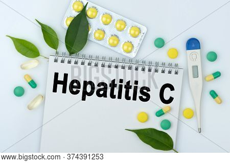 On The Table Are Pills, A Thermometer, Leaves And A Notebook With The Inscription -hepatitis C. The 