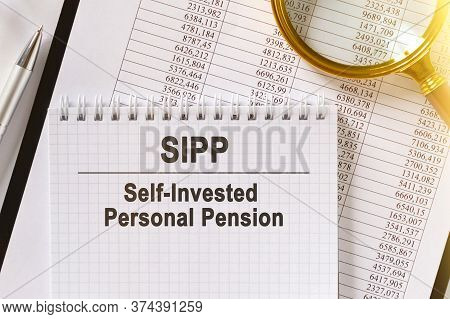 On The Table Are Financial Reports, A Pen, A Magnifying Glass And A Notebook With The Inscription - 