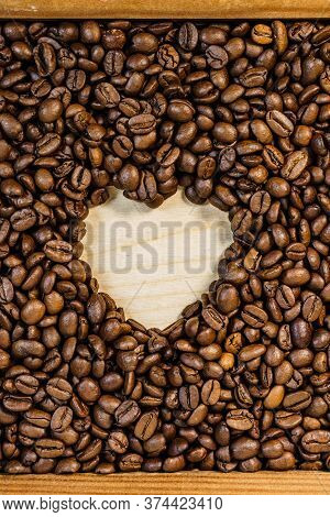Roasted Brown Coffee Beans With Empty Heart Form Shape.