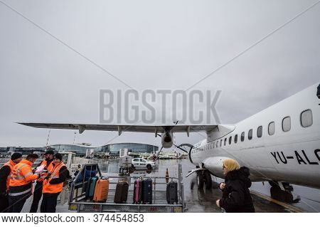 Bucharest, Romania - February 11, 2020:luggage Handlers Taking Care Of The Baggage Of An Atr 72 That