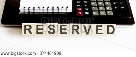 Business Concept Text On Wood Block Reserved With Calculator, Notebook And Laptor On White Backgroun