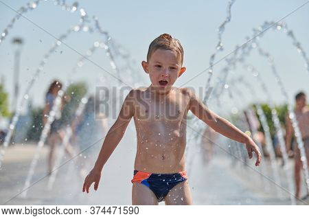 Voronezh, Russia - 24.08.2019 - Cute Boy Playing In Fountain. Little Boy Playing With Waterspouts. E