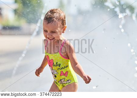 Voronezh, Russia - 24.08.2019 - Cute Baby Playing In Fountain. Little Girl Playing With Waterspouts.