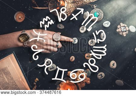 Astrology. The Witchs Female Hands Point To The Runestone. On A Black Background Lie Fortune-telling