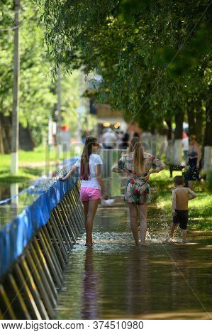 Vadul lui Voda, Criuleni, Moldova, June 2020: People play with water leaked through barriers set to prevent flood caused by Dniester river spill after heavy rains in Vadul lui Voda beach area