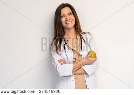 Medical Doctor Woman Smile With Stethoscope Hold Dreen Fresh Apple In Hand. Isolated Over White Back