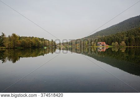 Beautiful Landscape In Spring With Mountains And Trees Reflecting On A Calm Lake Like A Mirror, Refl