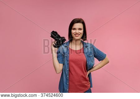 Portrait Of Young Female Photographer Isolated On Pink Background With Copy Space. Photographer With