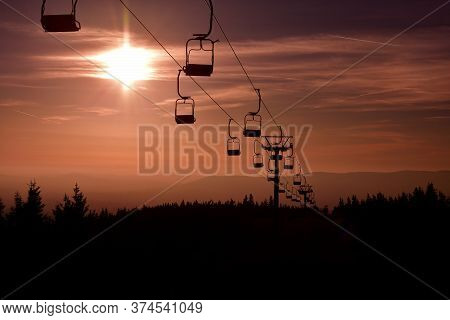 Ski Chair Lift In The Mountains At Red Sunset