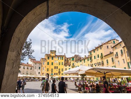 Lucca, Italy - August 14, 2019: View Through The Arch Ancient Amphitheater Square Or Piazza Dellanfi