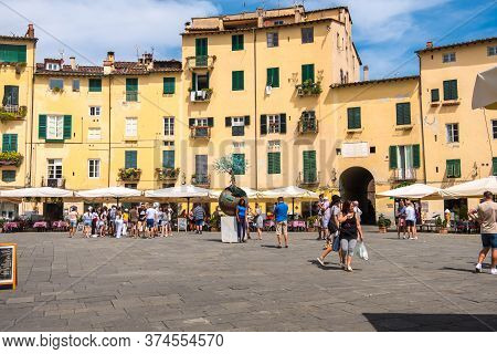 Lucca, Italy - August 14, 2019: Tourists And Locals Visit Ancient Amphitheater Square Or Piazza Dell