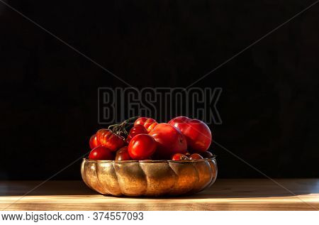 Fresh Red Organic Tomatoes In Old Brass Or Copper Bowl On Wooden Table. Low Key Immage. Copy Space