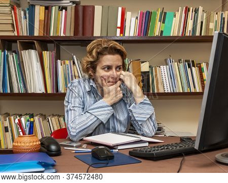 Image Of A Busy Woman Teleworking At Her Desk At The Home. Working At Home Became An Important Recom
