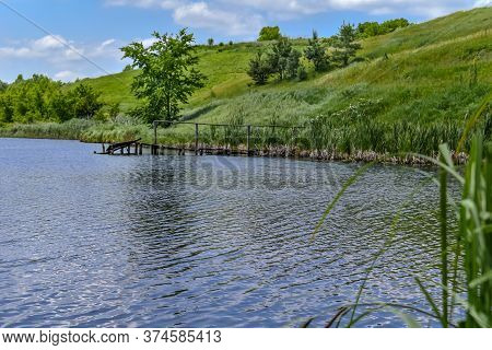 Beautiful Landscape Of Lake With Old Wooden Dilapidated Pier On Meadow. Delightful Nature Of Sumy Re