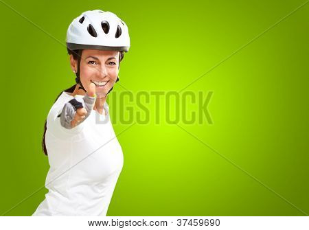 Femme portant casque montrant le pouce en haut isolé sur fond vert