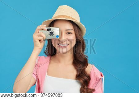 Attractive Energetic Asian Woman Happily Holding Cemara Isolated On Blue Studio Background