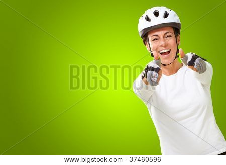 Femme portant casque montrant les deux pouces vers le haut isolé sur fond vert