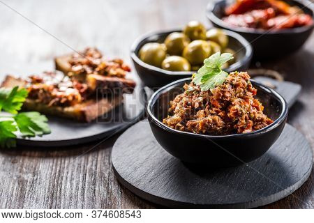 Tapenade - delicious olive paste from France with ingredients and crostini.