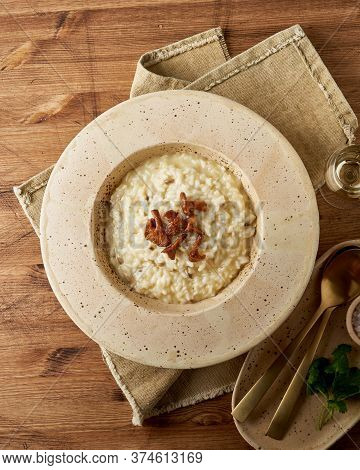 Risoto With Chanterelle Mushrooms In Large Plate. Traditional Italian Dish. Wooden Old Table