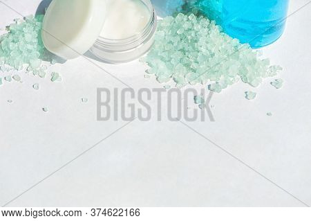 Blue Gel In A Bottle, White Cup, Blue Bath Salt, Cream In A Jar On A White Background. Copy Space