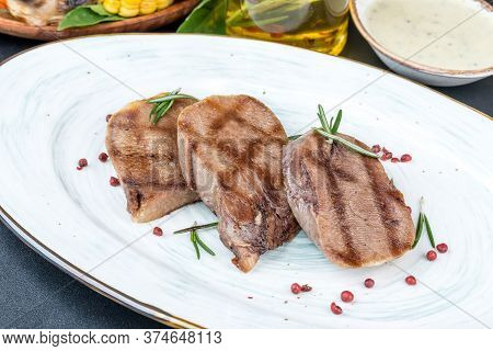 Grilled Veal Tongue Served On A White Plate