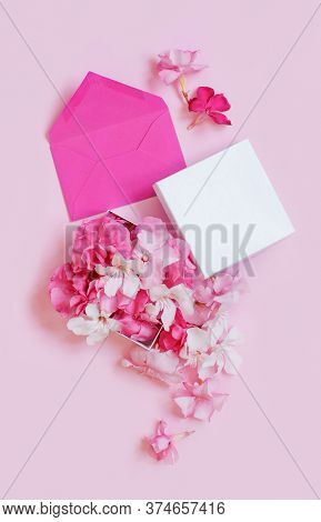 Pink Envelope And Gift Box Full Of Flowers  Over A Pink Background Top View
