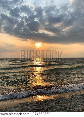 The Setting Sun Is Reflected In The Sea, Leaving A Beautiful Bright Path On The Water.