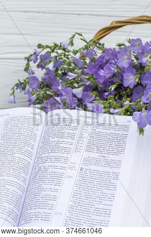 Novomoskovsk, Ukraine - June 15, 2020: Open Bible And Bouquet Flax In Wicker Basket