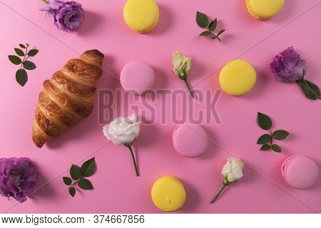 French Pastry - Macarons And Croissant With Flowers On Pink Background. Top View