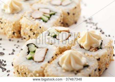 Maki Sushi - Roll lavet af kød og agurk inde. Sesam ouside. Toppet med flødeost