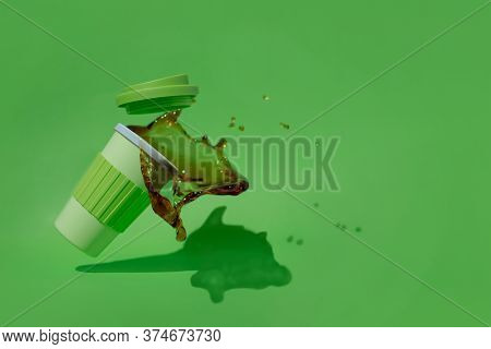Plastic Cup Of Coffee Falling And Spilled On A Green Background.