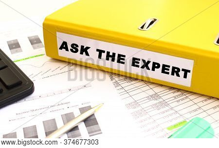 The Yellow Document Folder Is On The Office Desk. Nearby A Calculator And Finance Graphs. Inscriptio