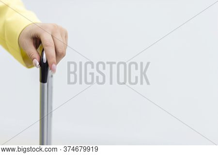 Cropped Shot Of Female Hand Carrying A Suitcase Over White Background With Copyspace.