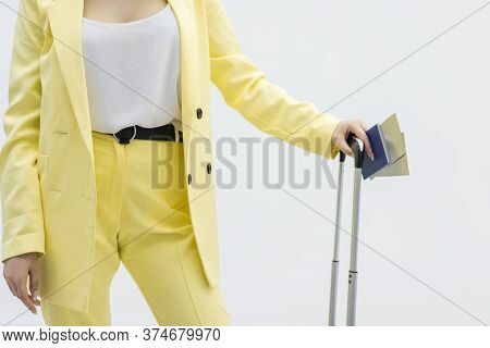 Cropped Shot Of Female Carrying A Suitcase And Pssport Over White Background With Copyspace.