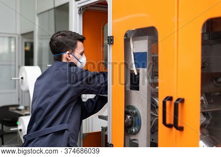 A Worker Stands At The Machine In A Factory For The Manufacture Of Medical Masks With Nanofiber. Cor