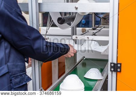 A Worker Stands At The Machine In A Factory For The Manufacture Of Medical Masks With Nanofiber. Cor