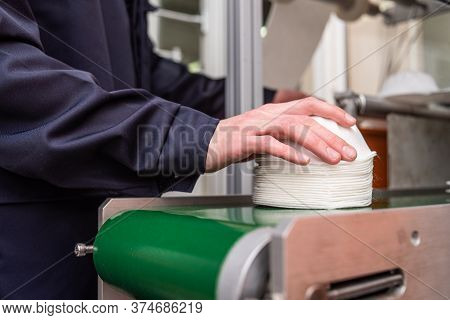 A Worker Stands At The Machine In A Factory For The Manufacture Of Medical Masks With Nanofiber. Cor