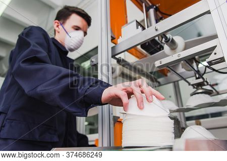 A Worker Stands At The Machine In A Factory For The Manufacture Of Medical Masks With Nanofiber. Cor