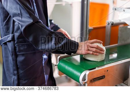 A Man Works At A Machine For The Manufacture Of Medical Masks With Nanofiber. Coronovirus And Covid-