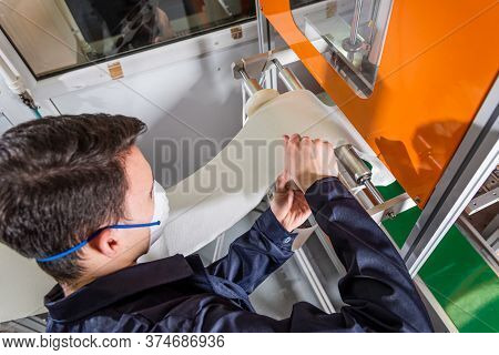 A Man Works At A Machine For The Manufacture Of Medical Masks With Nanofiber. Coronovirus And Covid-