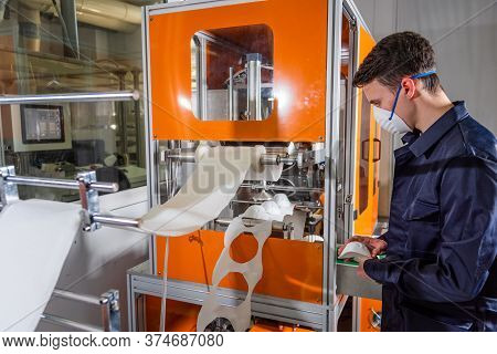 A Man Works At A Machine For The Manufacture Of Medical Masks With Nanofiber. Coronovirus And Covid-