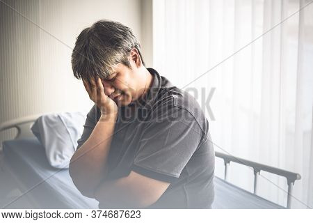 An Asian Middle Aged Man Sitting On A Patien's Bed Is Suffering From Stress From Their Own Illness T