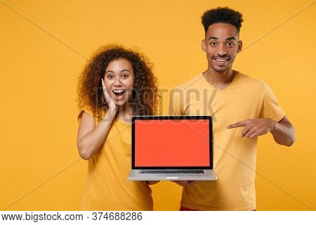 Amazed Friends Couple African American Guy Girl In Casual Clothes Isolated On Yellow Background. Peo