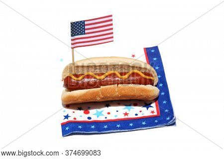 Hot Dog. Hot Dog with an American Flag on a Patriotic Napkin. Isolated on white. Room for text. Holiday Picnic Food. Hot Dogs are the Perfect Holiday and Picnic Food for the 4th of July. 