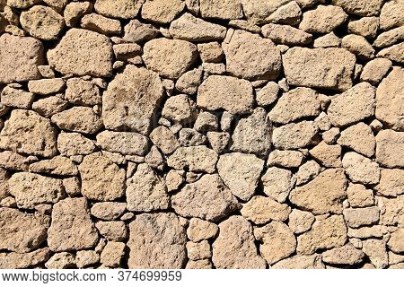 Rustic Wall Of Beige Stones For Background.